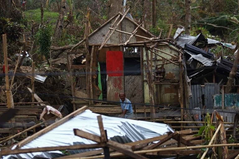 A resident gathers wood as he tries to fix